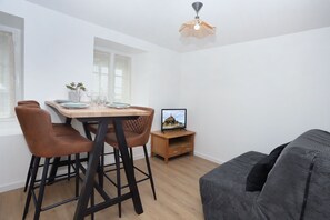 Un espace de vie moderne comprenant un coin repas, un canapé et un téléviseur.
