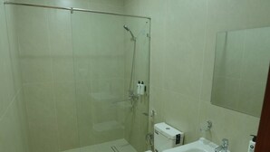 A bathroom with a glass-enclosed shower, a toilet, and a sink with a mirror. - Darvaza Boutique Hotel (Bukhara)
