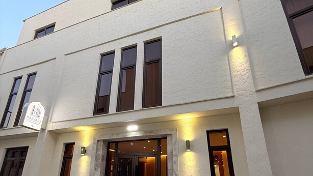 A modern building with a sign indicating 'DARVAZA' and a set of double doors at the entrance. - Darvaza Boutique Hotel (Bukhara)