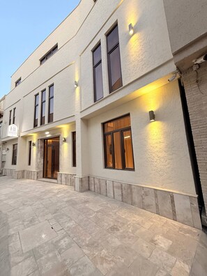 A multi-story building with a flat facade, large windows, and exterior lighting. - Darvaza Boutique Hotel (Bukhara)