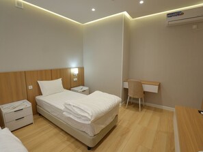 A hotel room with a bed, bedside tables, a desk, and a chair. - Darvaza Boutique Hotel (Bukhara)