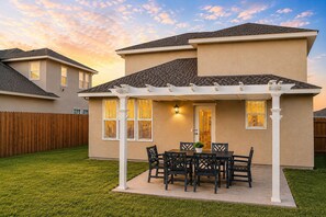 A residential house with a covered patio, a fenced backyard, and a well-maintained lawn. - Luxury 3BR - Office -  Pool -  Fast WiFi (MCALLEN)