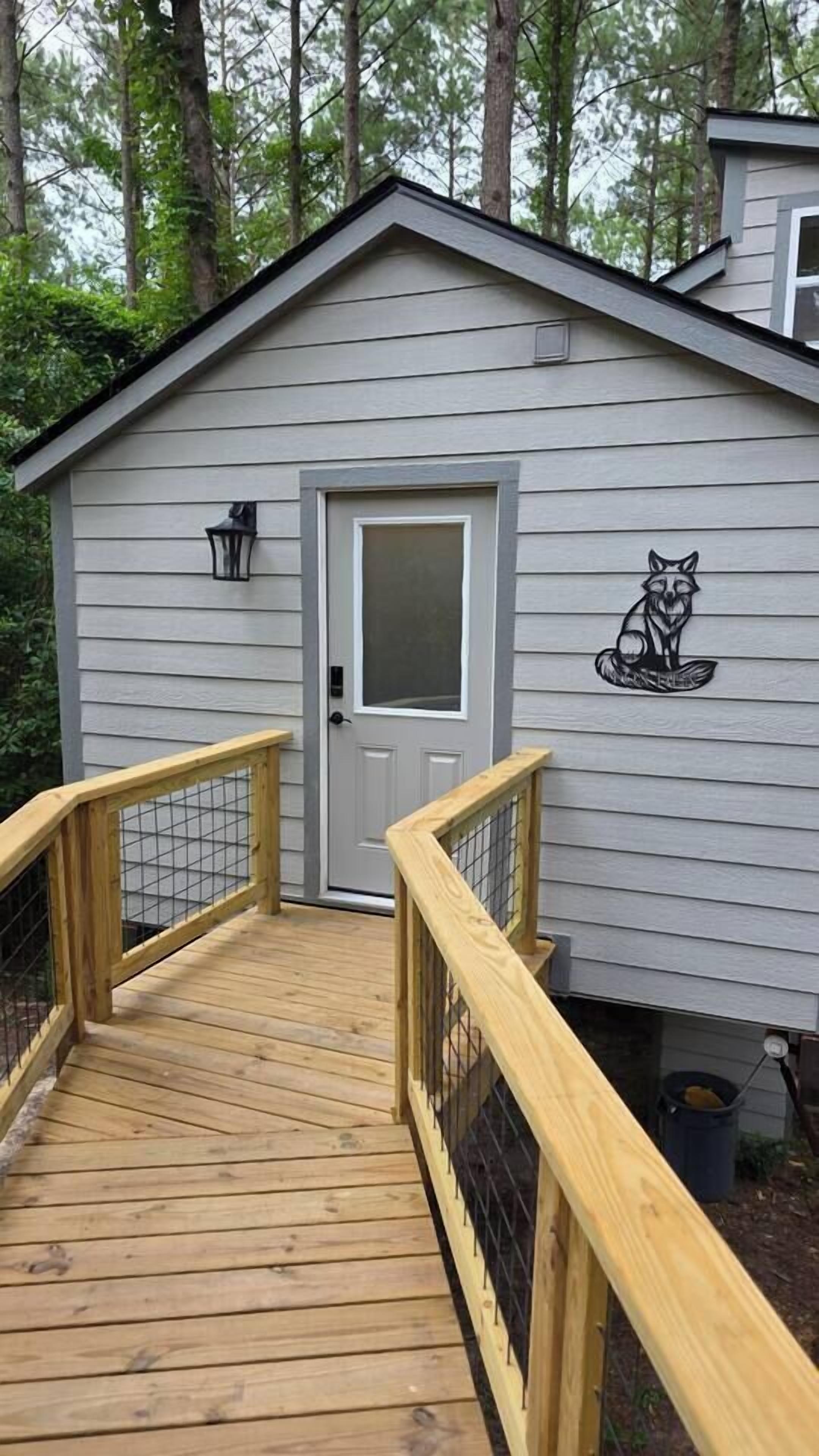 A wooden deck leading to a shed with a door and a fox decal.