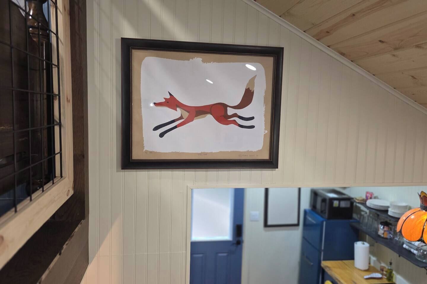 Una obra de arte enmarco con un zorro en la pared.