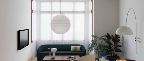 A modern living room with a sofa, coffee table, and chairs, a dining table with a bowl, and a large window with curtains.