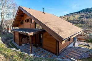 Eine Holzhütte mit geneigtem Dach, einer Veranda und einem Steinfundament.