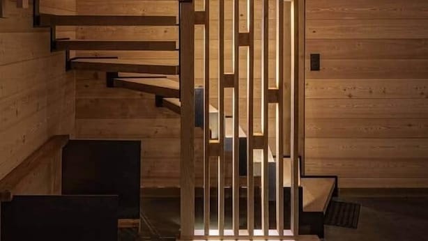 Eine Holztreppe mit modernem Design, die zu einer höheren Ebene führt.