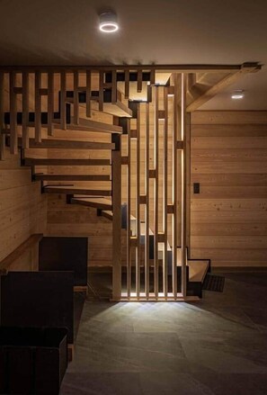 Een houten trap met een modern ontwerp, die naar een hoger gelegen niveau leidt.