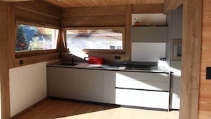 Eine kleine Küche mit Fenster, Einbaukästen und einer Arbeitsplatte.