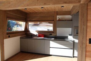 Eine kleine Küche mit Fenster, Einbaukästen und einer Arbeitsplatte.
