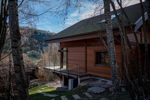 Een moderne blokhut met een balkon dat uitkijkt over een vallei.