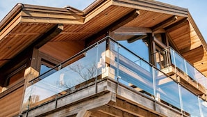 Ein modernes Holzgebäude mit einem Glasbalkon.