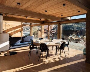 Een moderne eetruimte met een ronde tafel, stoelen en uitzicht op de omgeving.