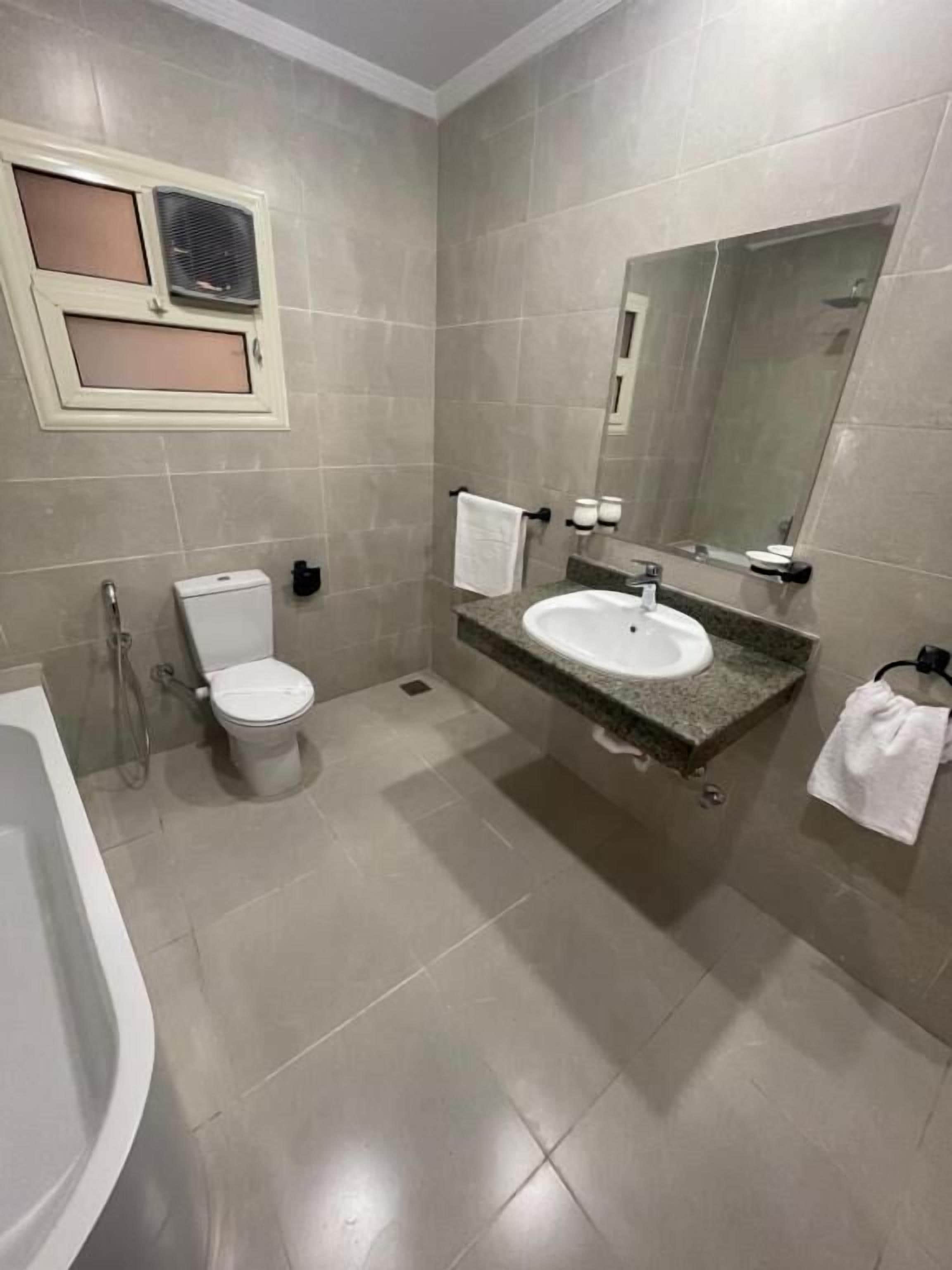 Un baño con inodoro, lavamanos y bañera.