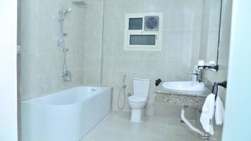 Un bany modern amb una banyera independent, un vàter i un lavabo.