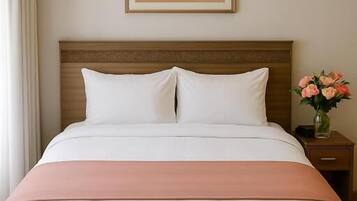 Habitación de hotel con cama, mesita de noche con un florero y un aire acondicionado instalado en la pared.