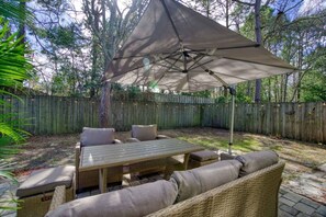 An outdoor patio with a table and chairs, a canopy, and a wooden fence in the background. - Bright Horizons Hideaway w/POOL- 18 min to MAYO (Jacksonville)