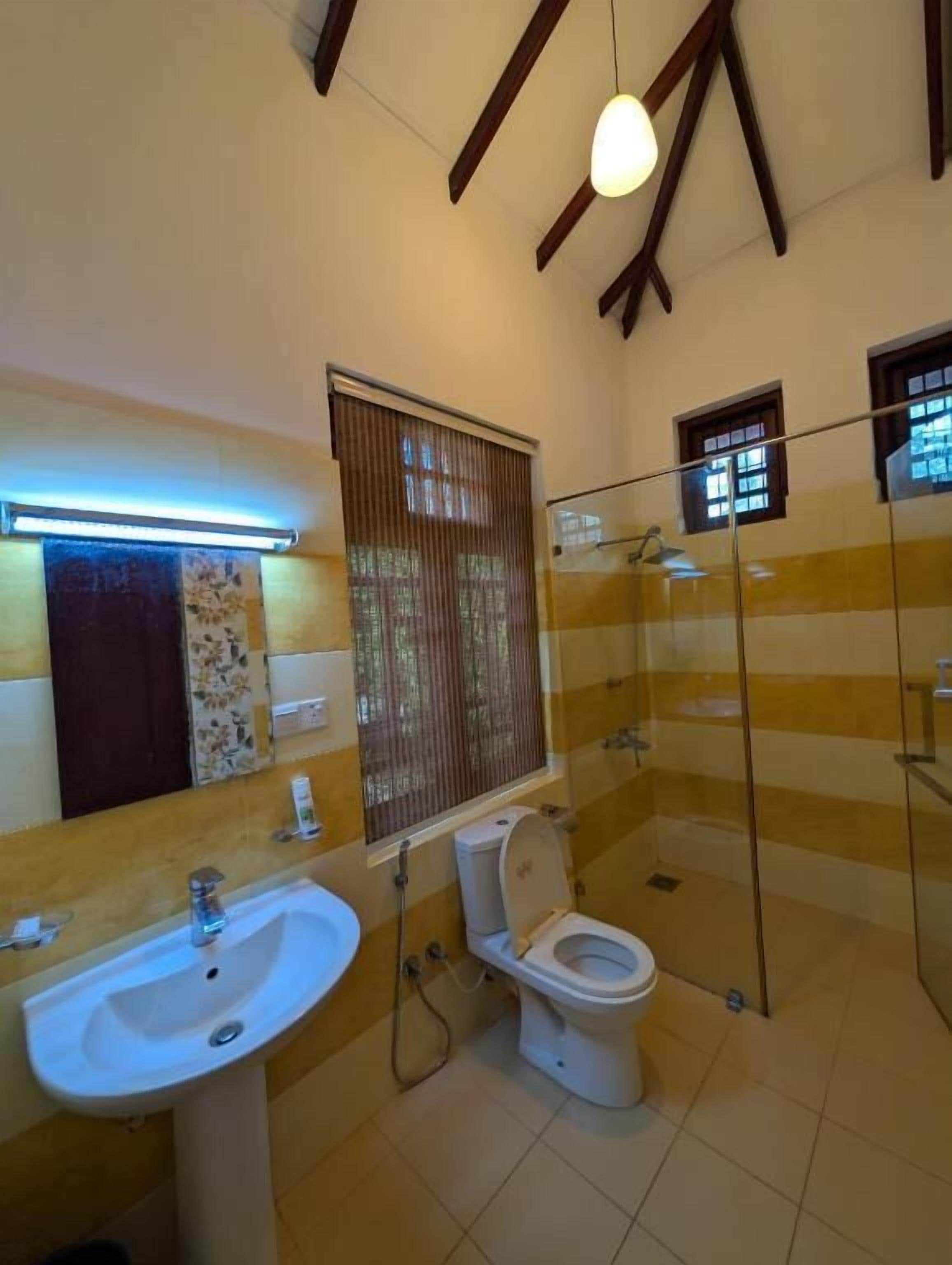 Ein Badezimmer mit Waschbecken, Toilette und Duschkabine aus Glas.