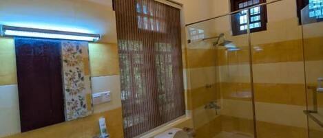 Un baño con lavamanos, inodoro y cabina de ducha de vidrio.