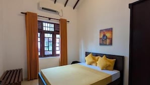 Un dormitorio con cama, ventana con cortinas, un cuadro en la pared y techo con vigas de madera.