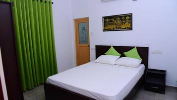 Un dormitorio con cama, mesita de noche, puerta y aire acondicionado instalado en la pared.