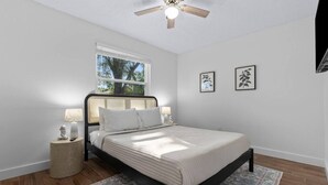 A bedroom with a bed, bedside tables, a window, and a ceiling fan. - San Pablo Retreat Near Mayo Clinic Mins to Beaches (Jacksonville)