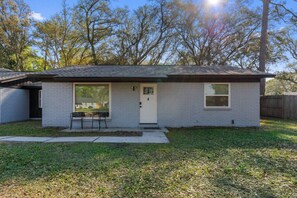 A single-story house with a front door, a small porch with two chairs, and a visible mailbox. - 10 Min to Mayo & Beach • Sleeps 5 • Clean & Quiet (Jacksonville)