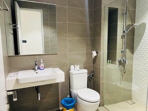 Baño con lavamanos, inodoro y ducha blancos.