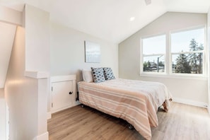 Ein Schlafzimmer mit Bett, Fenster und Tür.