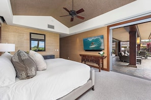 A hotel room with a bed, a television, a ceiling fan, a window with a view, and a door leading to an outdoor area. - Pakui Street Estate by Gather - Hualalai Golf Estate w/ Private Pool & Spa (Kailua Kona)