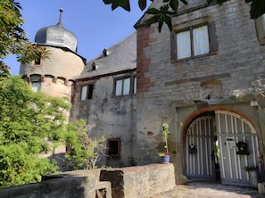 A historic building with a turret, a gated entrance, and a small window.