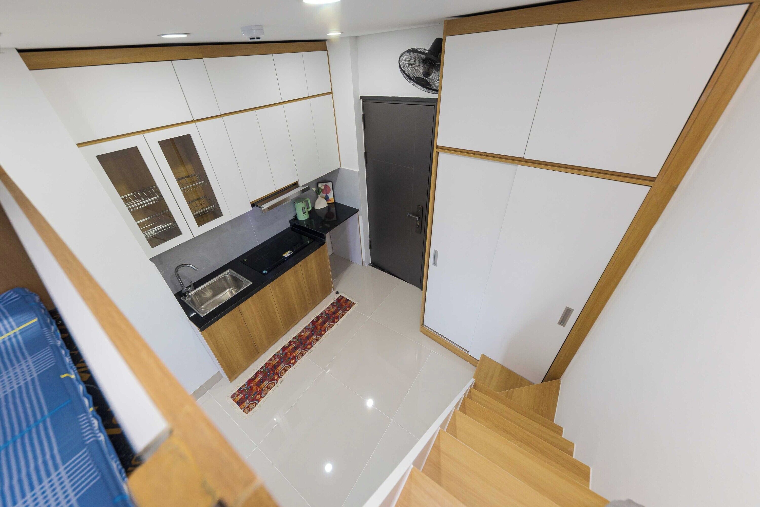 A compact kitchen with a sink, a coffee maker, and a refrigerator.