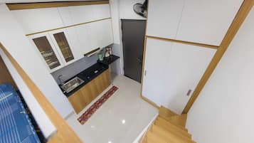 A compact kitchen with a sink, a coffee maker, and a refrigerator.