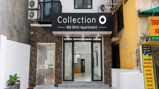 Un edificio con un letrero que dice 'Collection My Binh Apartment' y una entrada visible con una puerta y escalones que conducen a ella.