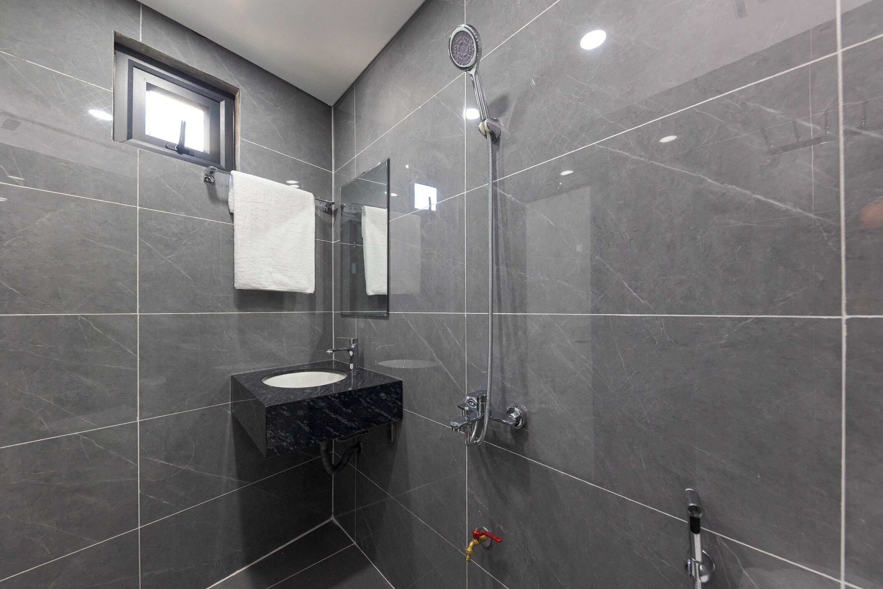 A modern bathroom with a sink, mirror, and shower.