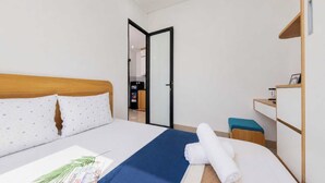 Habitación de hotel con cama, escritorio, silla y armario.