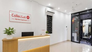 Mostrador de recepción con un cartel que dice 'Collection My Dinh Apartment'.