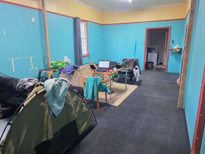 A room with a tent, a table with a laptop, and a chair.