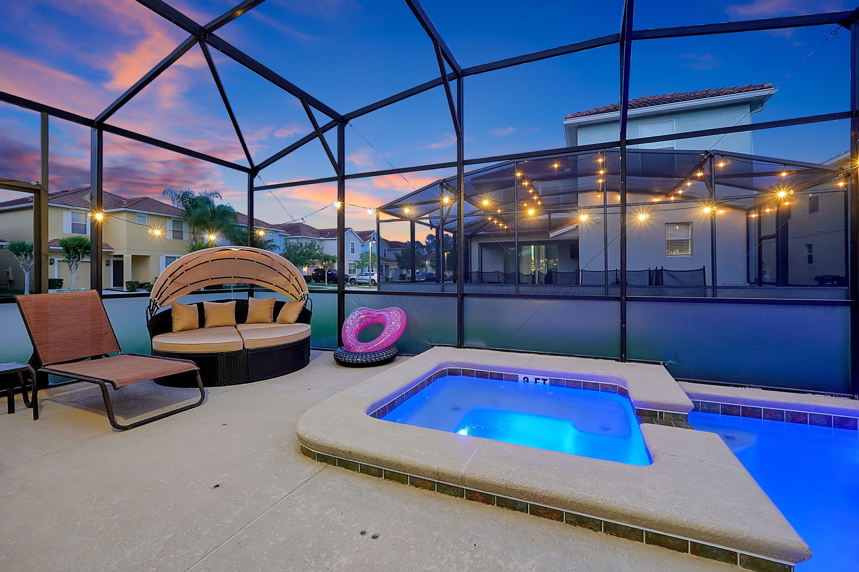 Un espace piscine comprenant un jacuzzi, des chaises longues et un coin salon abrité.