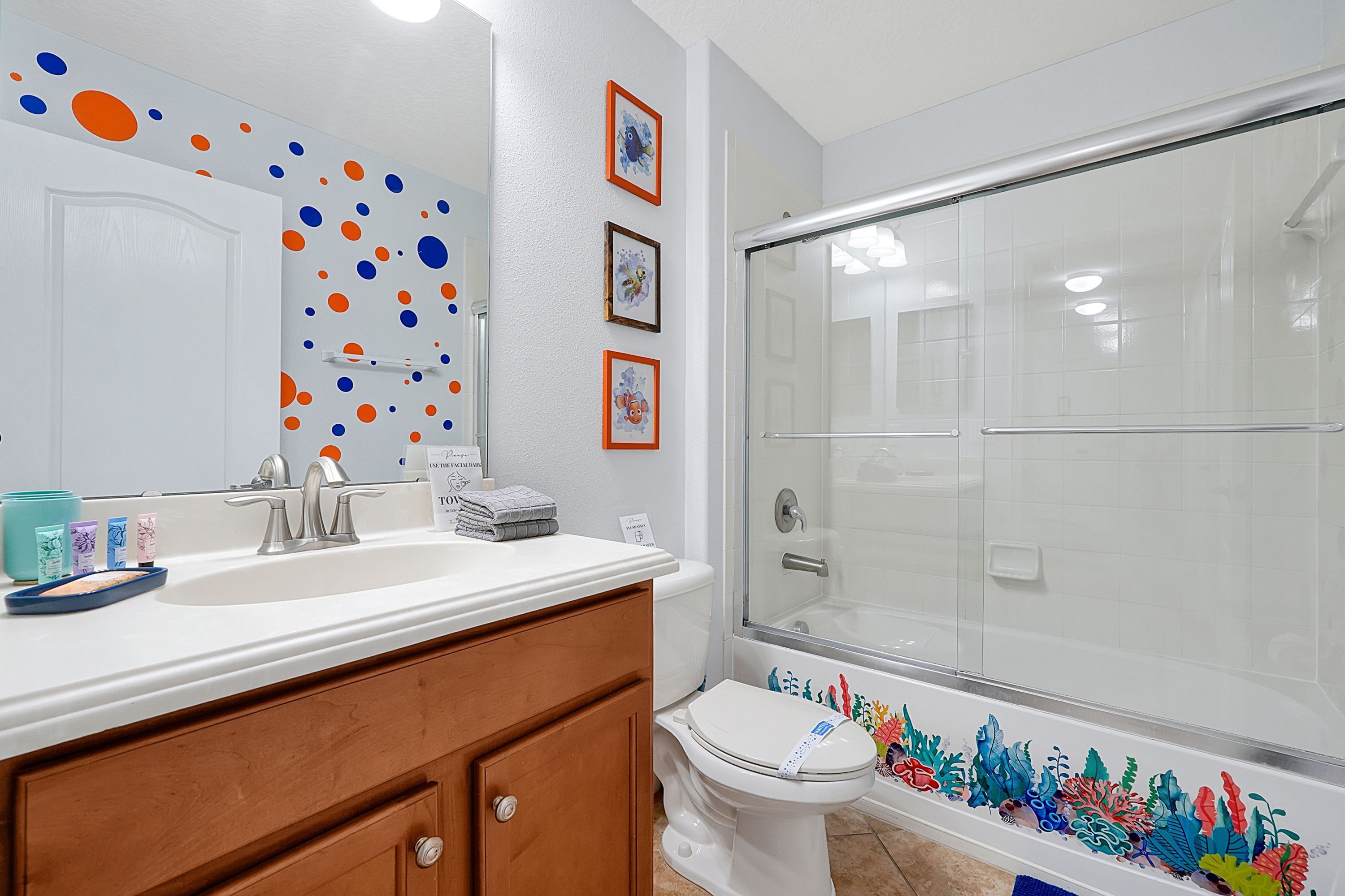 A bathroom with a white sink, a toilet, and a glass shower enclosure.
