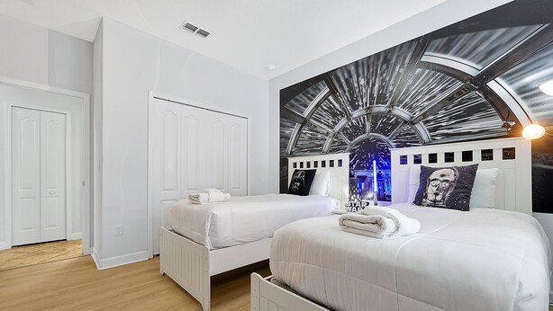 A hotel room with two beds, a large wall mural, and a white door. - Wish Upon A Star in Kissimmee (Kissimmee)