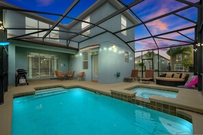 A pool area with a glass-enclosed patio, outdoor seating, and a clear view of the sky. - Wish Upon A Star in Kissimmee (Kissimmee)