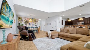 A spacious living room with a large sectional sofa, a massage chair, and a dining area with a table and chairs. - Wish Upon A Star in Kissimmee (Kissimmee)