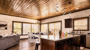 A spacious kitchen with a central island, wooden ceiling, and large windows. - Skydeck Pinnacle in Sevierville (Sevierville)