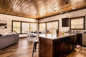 A spacious kitchen with a central island, wooden ceiling, and large windows. - Skydeck Pinnacle in Sevierville (Sevierville)