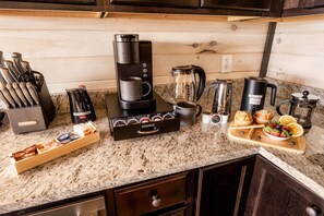 A kitchen with a coffee maker, coffee grinder, kettle, and various coffee pods. - Skydeck Pinnacle in Sevierville (Sevierville)