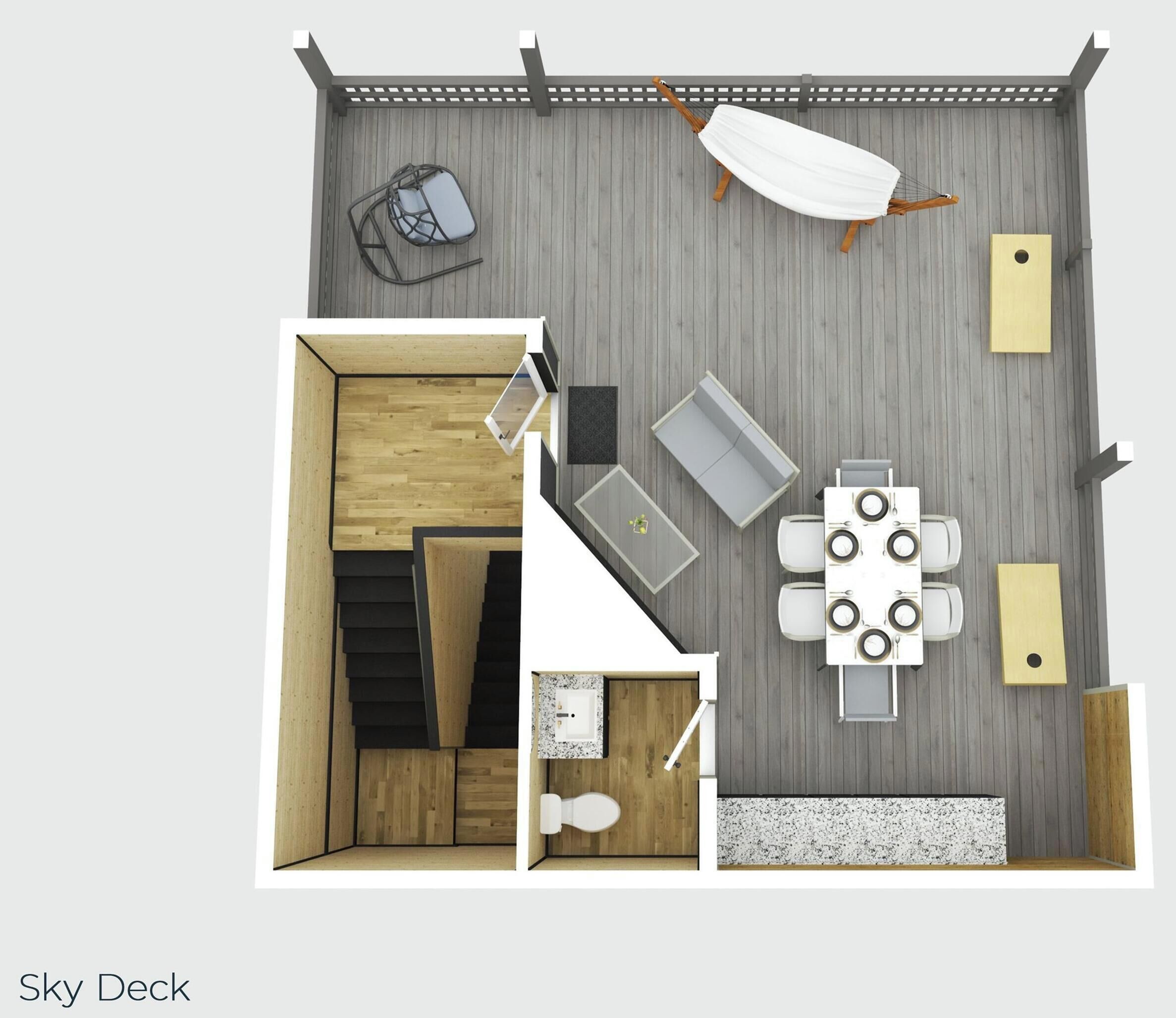 A room with a wooden floor, a white sofa, a dining table with chairs, a small kitchen area, and a window.