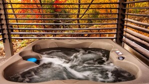 A hot tub with a view of autumn foliage through a metal railing. - Skydeck Pinnacle in Sevierville (Sevierville)