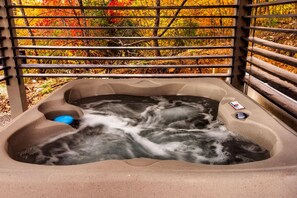 A hot tub with a view of autumn foliage through a metal railing. - Skydeck Pinnacle in Sevierville (Sevierville)