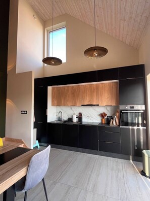 A modern kitchen with black cabinets, a marble countertop, and a stainless steel oven. - TyGwenHaJu (Plounéour-Brignogan-plages)